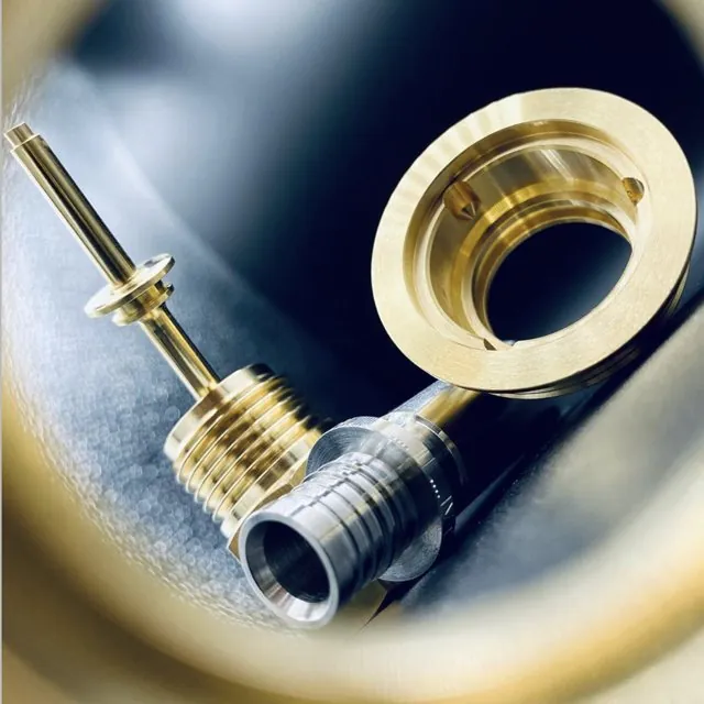Brass valve component being precision-turned on a lathe