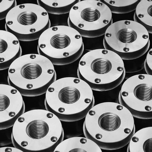 Rows of machined flanged nuts with threaded bores