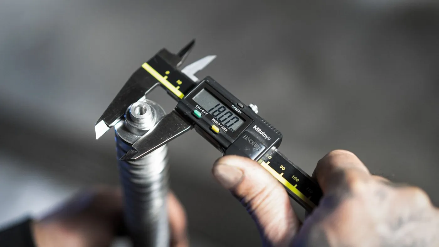 Digital caliper measuring a precision turned brass component