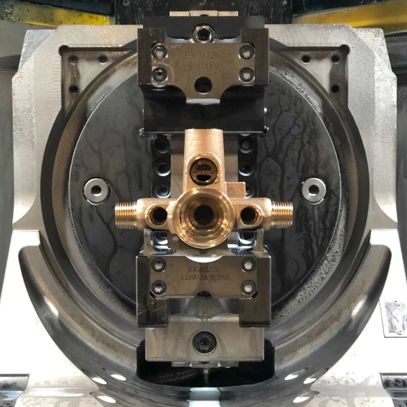Forged brass fitting clamped in a CNC chuck for machining at Brassland