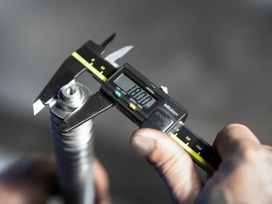 Mitutoyo digital caliper measuring the diameter of a machined part at Brassland