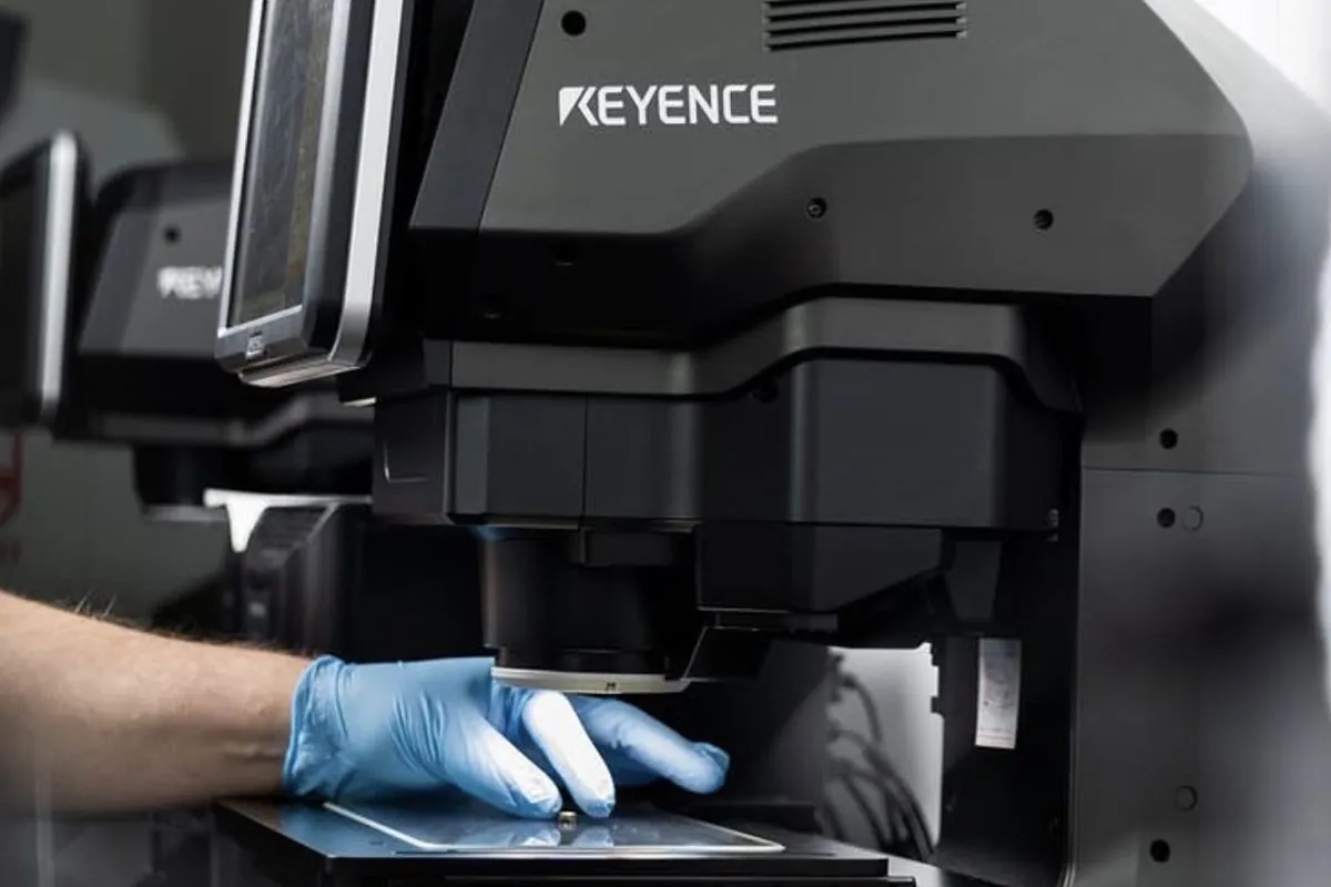 Keyence high-magnification optical measurement microscope with an operator at Brassland